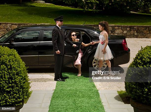 chauffeur helping wealthy woman out of car. - high society ストックフォトと画像