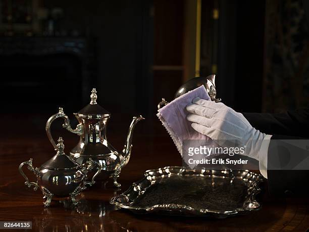 butler polishing silver serving set. - white glove stock-fotos und bilder