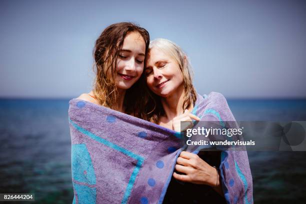 amar senior madre e hija adulta en toalla de playa - mother daughter towel fotografías e imágenes de stock