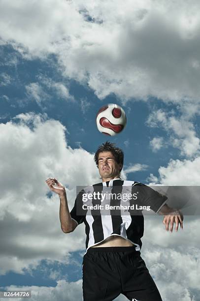 soccer player jumping, heading ball - moosinning stock pictures, royalty-free photos & images