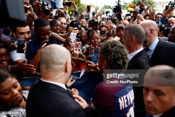 Neymar salutes the press as he arrives to pose with his new jersey after a press conference with Paris Saint-Germain President Nasser Al-Khelaifi on...