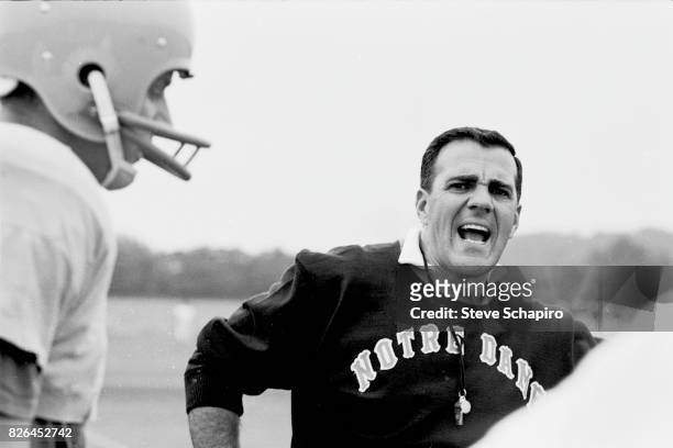 American college football coach Ara Parseghian , of the University of Notre Dame, talks to players on the field during a team practice, South Bend,...