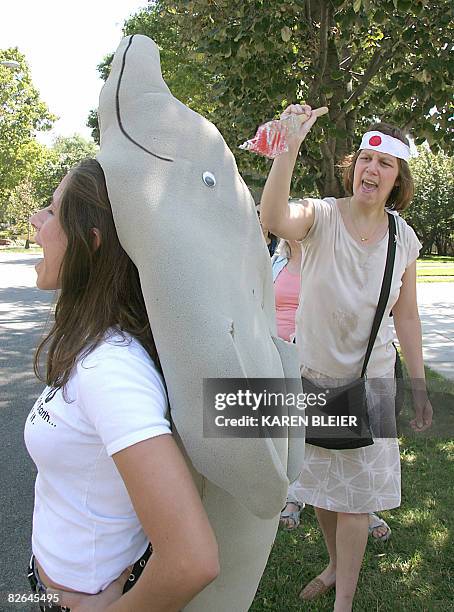 Kristin Martin, an activist portraying Japanese fishermen spears a "dolphin" during a protest in front of the Japanese Embassy September 3, 2008 in...