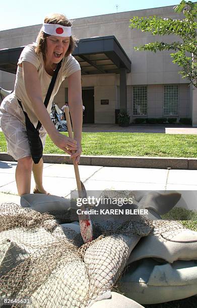 Kristin Martin, an activist portraying Japanese fishermen spears a "dolphin" during a protest in front of the Japanese Embassy September 3, 2008 in...