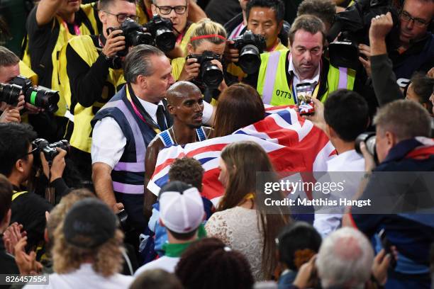 Mo Farah of Great Britain celebrates winning gold in the Men's 10000 metres final with his wife Tania Nell during day one of the 16th IAAF World...