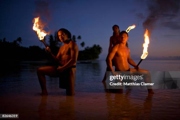 traditional tahitian fire dancer pose with torch i - tahiti stock pictures, royalty-free photos & images