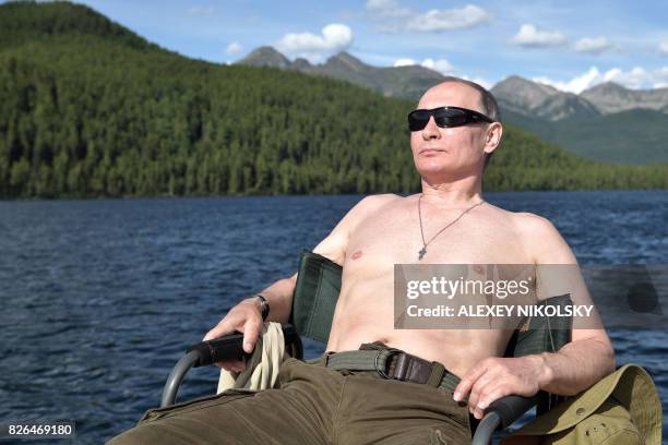 Russian President Vladimir Putin sunbathes during his vacation in the remote Tuva region in southern Siberia. The picture taken between August 1 and...