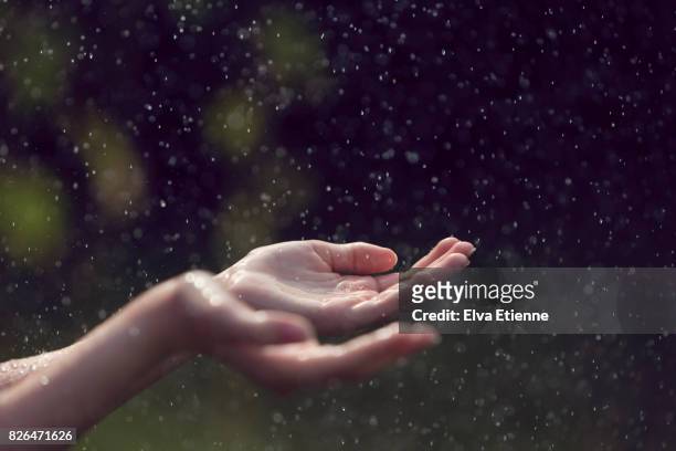 child catching falling raindrops in hands - sensory perception stock pictures, royalty-free photos & images