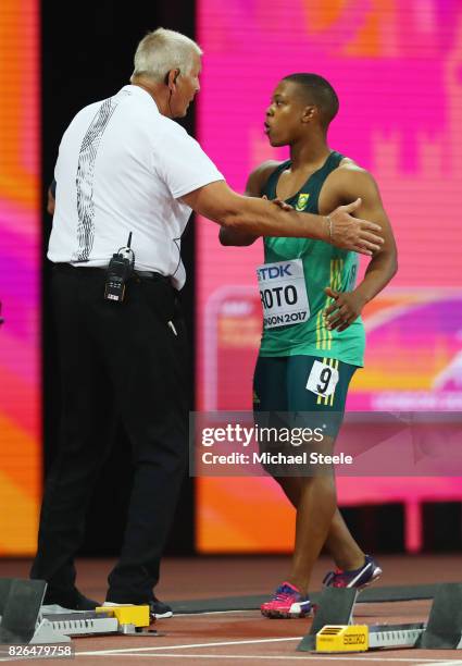 Thando Roto of South Africa speaks to the offical after being disqualified in the Men's 100 metres heats during day one of the 16th IAAF World...