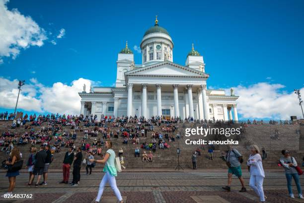 touristen sitzen auf stufen des helsinki kathedrale, finnland - helsinki stock-fotos und bilder