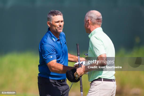 Tom Byrum and Gary Hallberg shake hands after finishing their round during the First Round of the 3M Championship at TPC Twin Cities on August 4,...