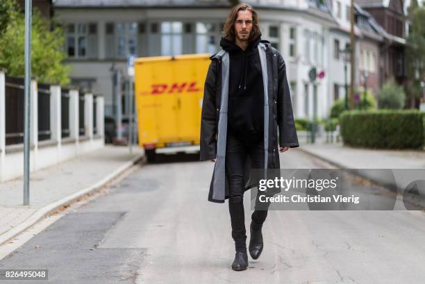 Model and Blogger Thomas Stuch wearing black oversized raincoat with a hood in black from Vetements, Stella McCartney hoodie in black, Dsquared slim...