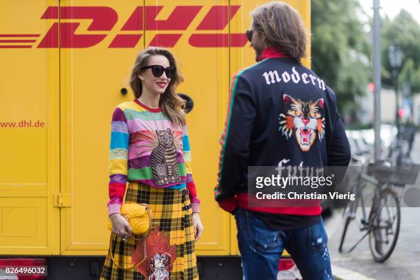 Couple look a like talking and flirting in front of DHL van - Model and Blogger Alexandra Lapp wearing a yellow and red pleated tartan skirt...