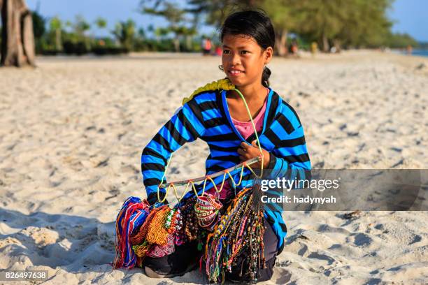 cambodian little girl selling handmade souvenirs on the beach, cambodia - trabalho infantil imagens e fotografias de stock