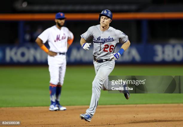 Chase Utley of the Los Angeles Dodgers rounds the bases as Amed Rosario of the New York Mets looks on after Utley hit a two run home run in the sixth...