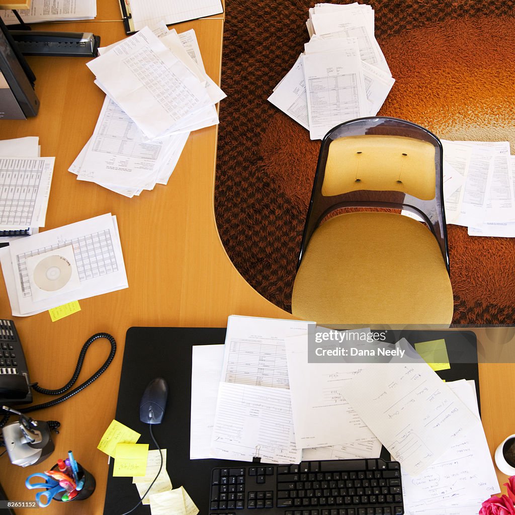 Cluttered desk in office, overhead view