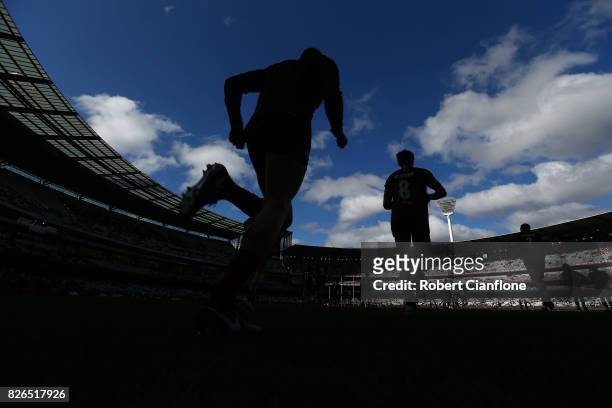 The Bombers run out for the warm up session prior to the round 20 AFL match between the Essendon Bombers and the Carlton Blues at Melbourne Cricket...