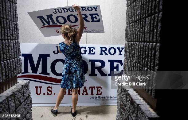 Judge Roy Moore campaign worker Maggie Ford collects campaign signs after the U.S. Senate candidate forum held by the Shelby County Republican Party...