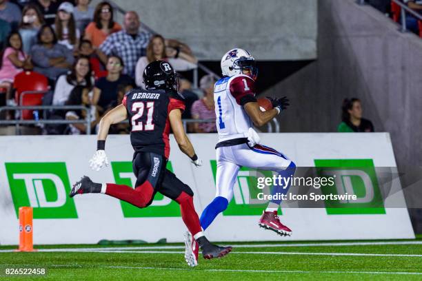 Montreal Alouettes wide receiver Tiquan Underwood glances back on his touchdown run to spot Ottawa RedBlacks defensive back Adam Berger during...