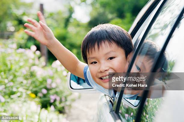a boy in a car waving his hand  - child waving stock pictures, royalty-free photos & images