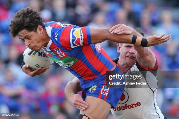 Dane Gagai of the Knights is tackled by the Warriors defence during the round 22 NRL match between the Newcastle Knights and the New Zealand Warriors...