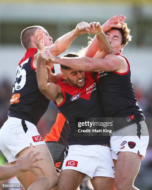 Christian Salem of the Demons competes for the ball with Tom McDonald and Michael Hibberd of the Demons during the round 20 AFL match between the...