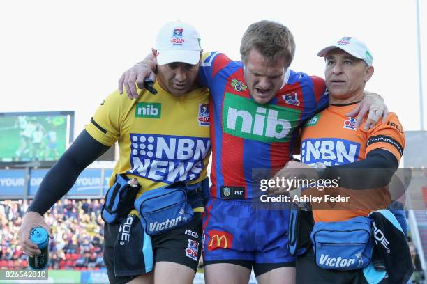 Nathan Ross of the Knights is carried off injured during the round 22 NRL match between the Newcastle Knights and the New Zealand Warriors at...