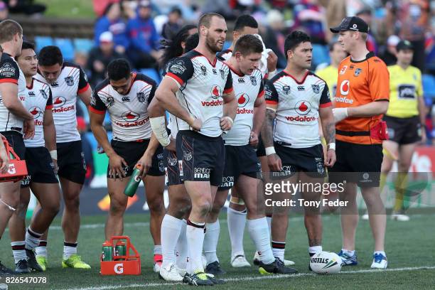 Warriors players look dejected during the round 22 NRL match between the Newcastle Knights and the New Zealand Warriors at McDonald Jones Stadium on...
