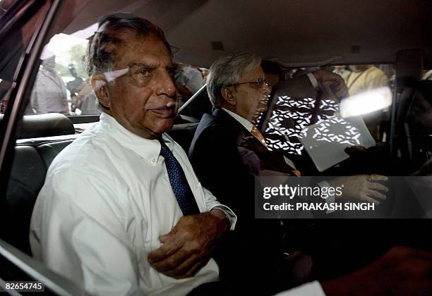 Chairman of India's Tata Motors Ratan Tata and Tata Motors Managing Director Ravi Kant leave after the inauguration of The Society of Indian...