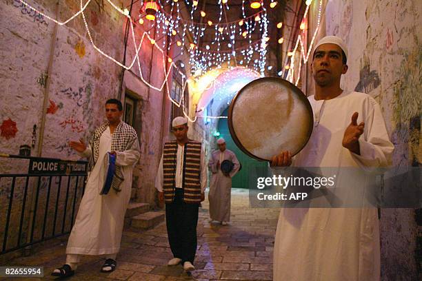 Palestinian Muslim youths play instruments as they call worshippers for Msaharati, the traditional Ramadan 3am wake-up call for a final meal before...