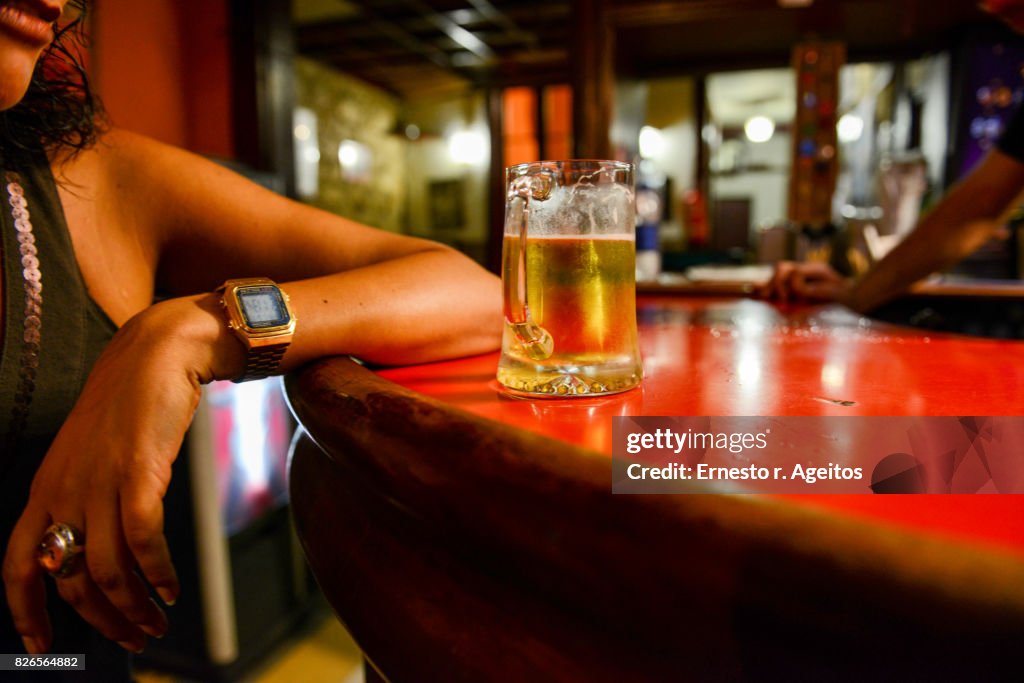 Young woman with a beer mug on a bar counter