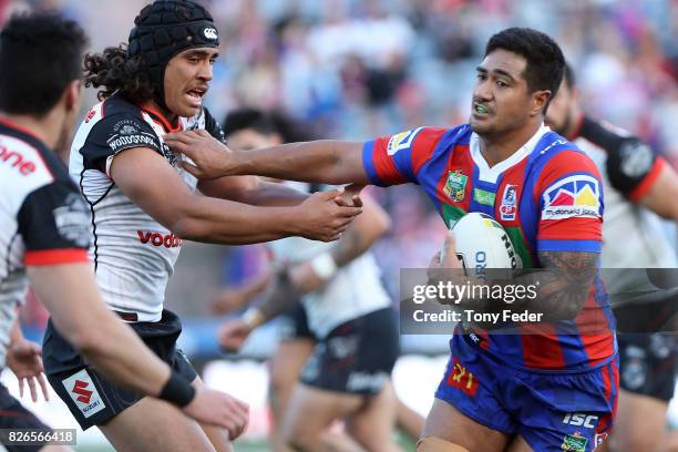 Peter Mata'Utia of the Knights fends off a tackle during the round 22 NRL match between the Newcastle Knights and the New Zealand Warriors at...