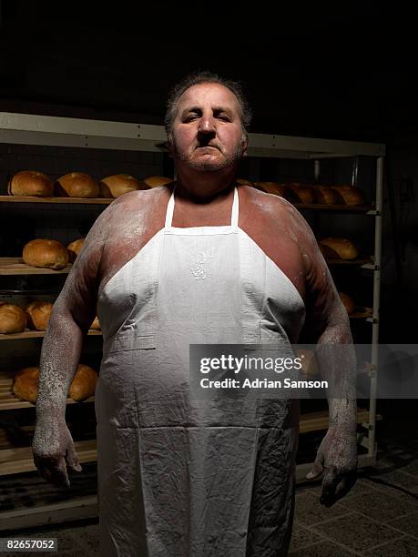 baker standing in front of rack of fresh bread - baker man stock-fotos und bilder