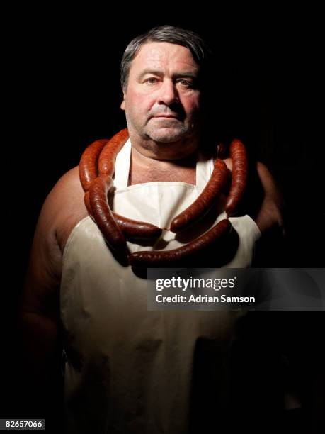 butcher wearing necklace of sausages - collar up stockfoto's en -beelden