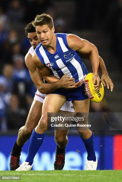 Andrew Swallow of the Kangaroos is tackled by Daniel Wells of the Magpies during the round 20 AFL match between the North Melbourne Kangaroos and the...