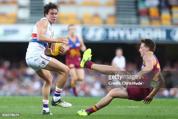 Lukas Webb of the Bulldogs is tackled by Alex Witherden of the Lions during the round 20 AFL match between the Brisbane Lions and the Western...