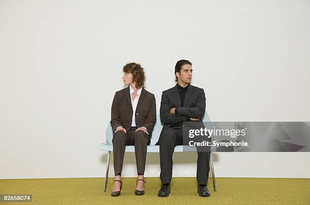 business people on bench in waiting room - sitting in a chair stockfoto's en -beelden
