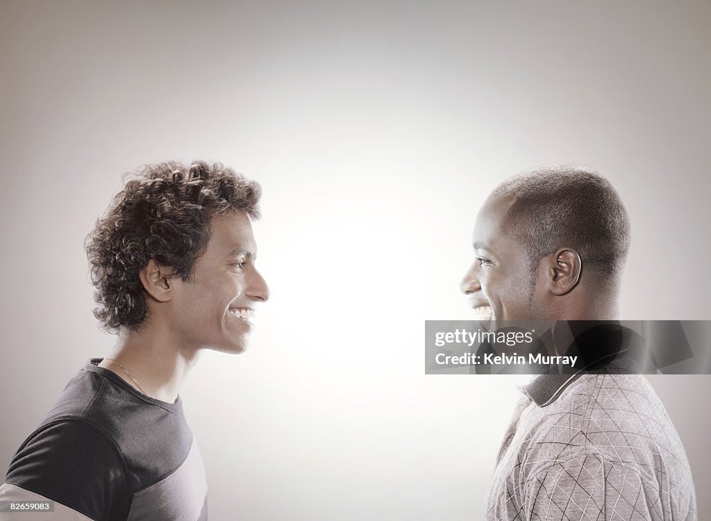 Two men facing each other and smiling