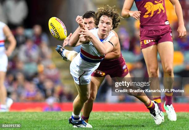 Liam Picken of the Bulldogs gets a handball away during the round 20 AFL match between the Brisbane Lions and the Western Bulldogs at The Gabba on...