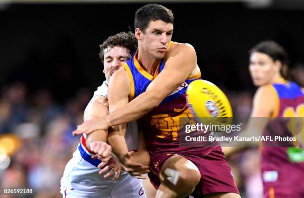 Jake Barrett of the Lions and Matthew Suckling of the Bulldogs challenge for the ball during the round 20 AFL match between the Brisbane Lions and...