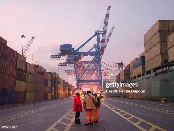 workers talking in a shipping yard - haven stockfoto's en -beelden