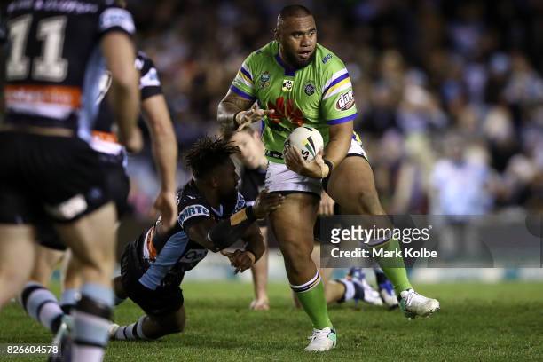 Junior Paulo of the Raiders breaks the tackle of James Segeyaro of the Sharks during the round 22 NRL match between the Cronulla Sharks and the...