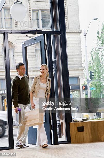man and woman walking in - entering shop stock pictures, royalty-free photos & images