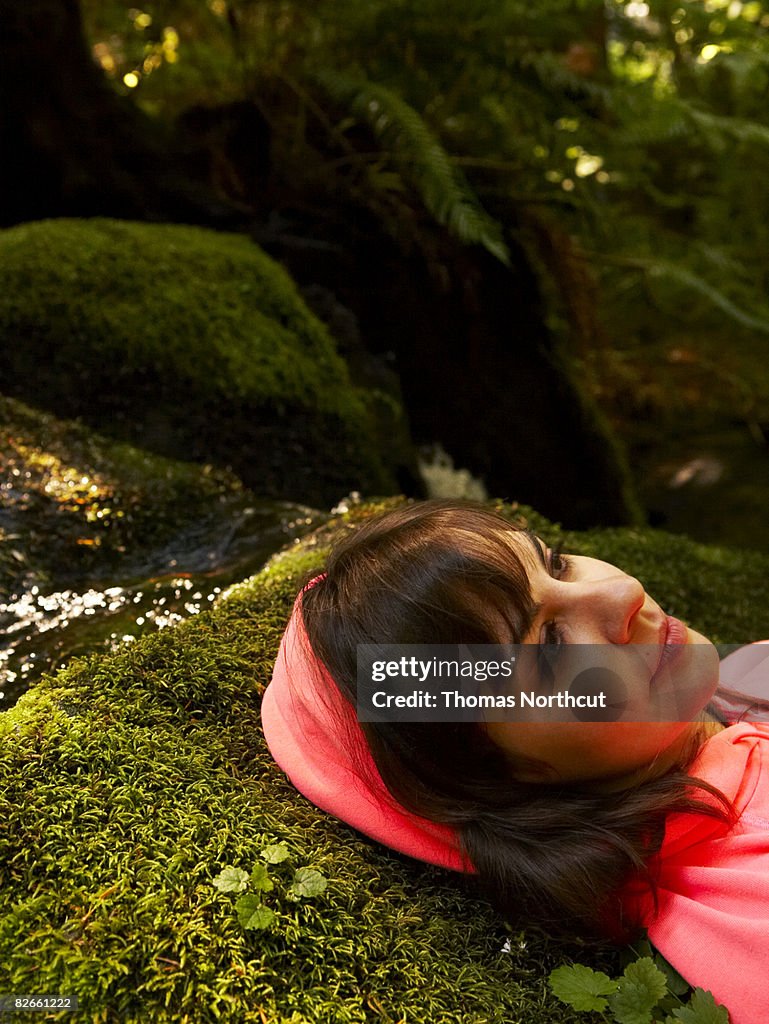 Young woman laying in forest