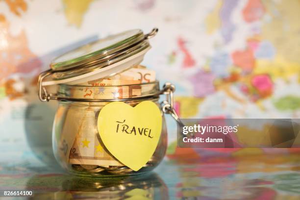 travel money savings in a glass jar with map in background and heart post it - budget 2017 stock-fotos und bilder