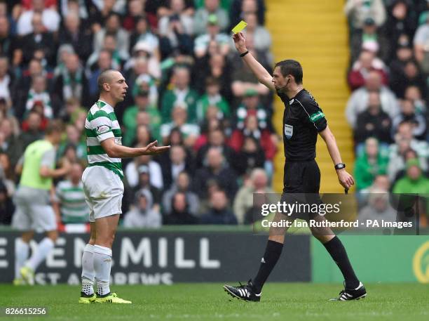 Referee Kevin Clancy shows Celtic's Scott Brown a yellow card during the Ladbrokes Scorrish Premiership match at Celtic Park, Glasgow.