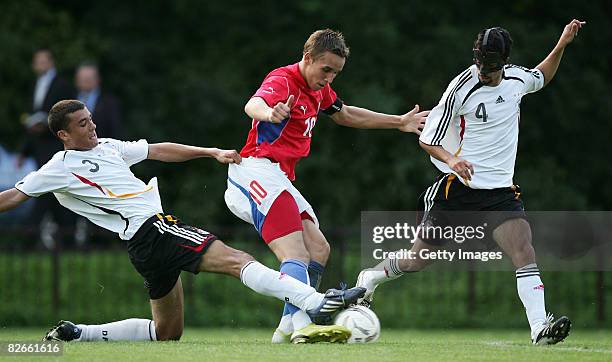 Josef Sural of Czech Rebublic, Manuel Gulde of Germany and his teammate Nils Teixeira fight for the ball during the U19 match between Czech Republic...