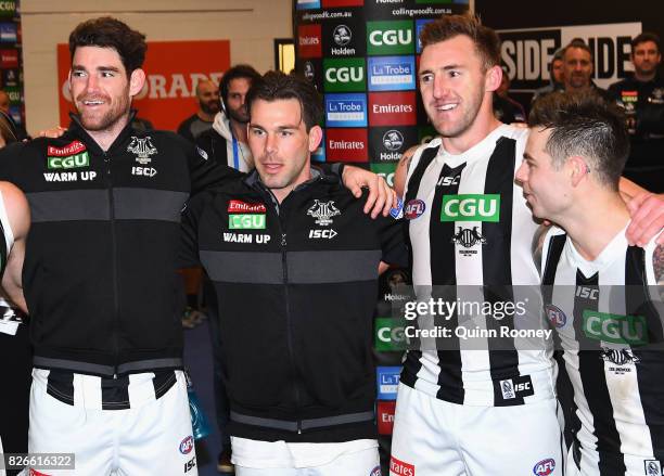 Tyson Goldsack, Levi Greenwood, Lynden Dunn and Jamie Elliott of the Magpies sing the song in the rooms after winning the round 20 AFL match between...