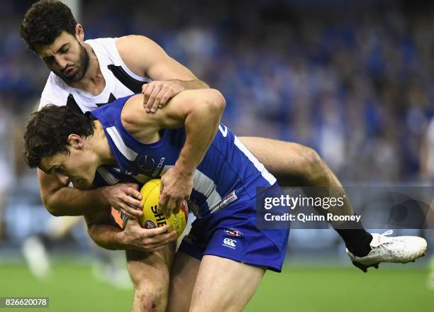 Scott Thompson of the Kangaroos is tackled by Alex Fasolo of the Magpies during the round 20 AFL match between the North Melbourne Kangaroos and the...