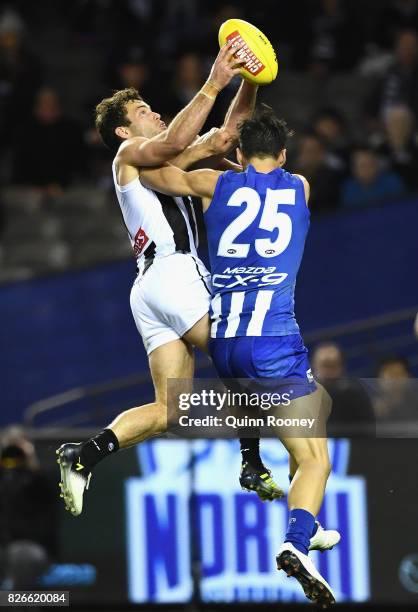 Jarryd Blair of the Magpies marks infront of Robbie Tarrant of the Kangaroos during the round 20 AFL match between the North Melbourne Kangaroos and...